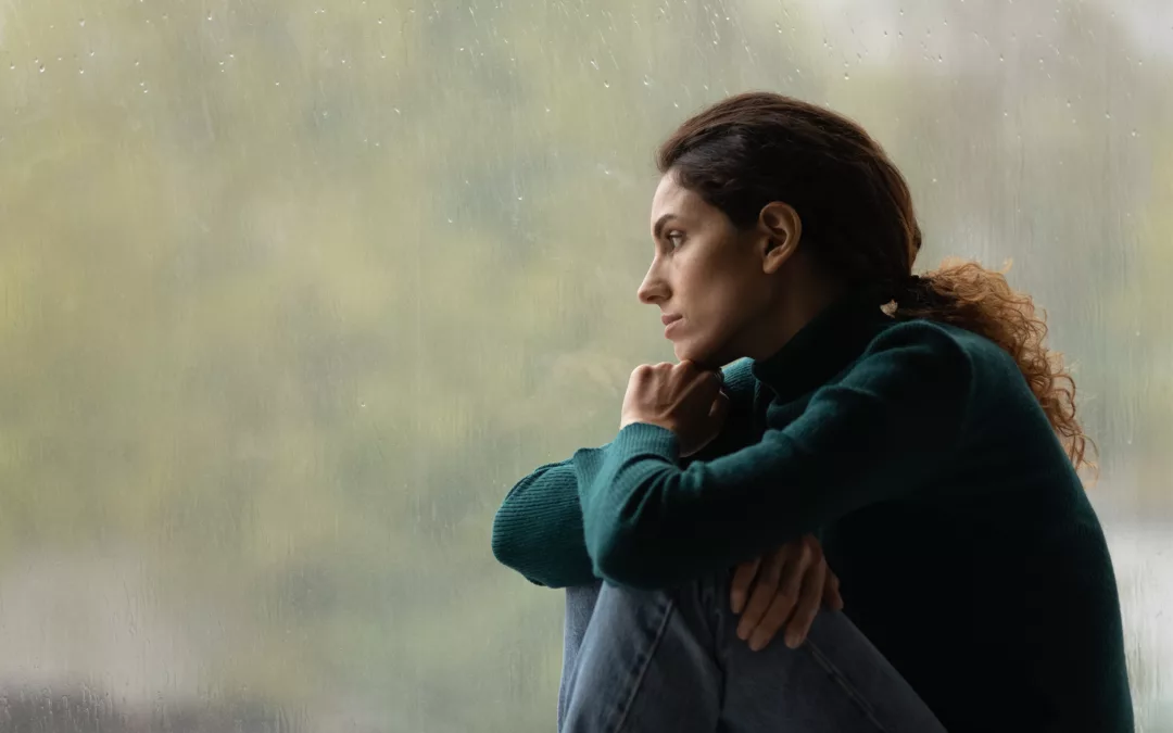 Side view of frustrated. thoughtful woman looking out rainy window in distance alone, lost in thoughts and upset